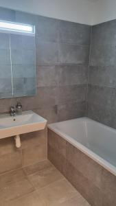 a bathroom with a sink and a tub and a mirror at Lovely 1 bedroom apt in middle of city centre in Blansko