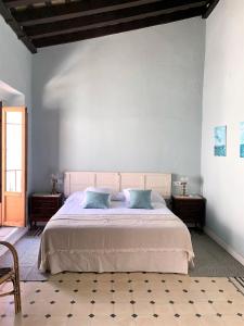 a bedroom with a large bed with blue pillows at Patios del Agua in El Puerto de Santa María