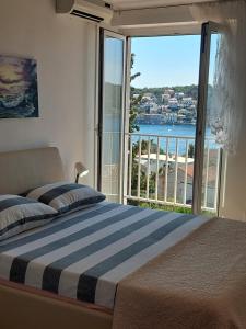 a bedroom with a bed and a large window at The Look in Mali Lošinj