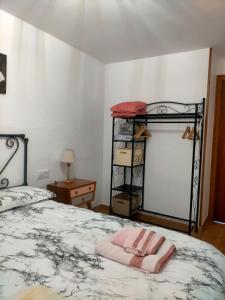 Un dormitorio con una cama con una toalla rosa. en Bajo los nidos 2, en San Emiliano