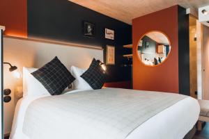 - une chambre avec un grand lit et un miroir dans l'établissement greet Hotel La Rochelle Centre, à La Rochelle