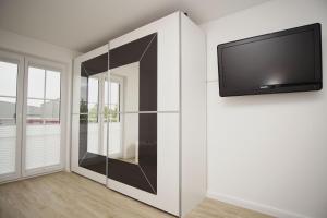 TV a/nebo společenská místnost v ubytování Nahe dem Seglerhafen, Balkon, eigene Sauna - Alte Fischfabrik Lauterbach FeWo 10