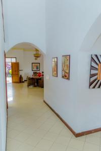 a hallway with a white wall with paintings on it at Select Boutique Hotel Kigali in Kigali