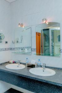 un bagno con due lavandini e un grande specchio di Select Boutique Hotel Kigali a Kigali