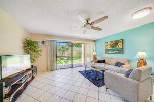 a living room with a couch and a tv at Kihei Gardens Estates G104 in Kihei