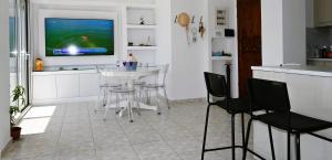 a kitchen with a table and chairs and a television at Efi's Luxury Suite in Agios Nikolaos
