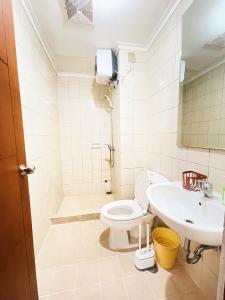 a bathroom with a toilet and a sink at Super Cozy 2BR Apt with direct access to Mall in Jakarta