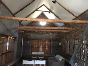 ein Wohnzimmer mit einer Decke mit Holzbalken in der Unterkunft Die Kapokbosskuur in Nieu-Bethesda + 33 Fotos