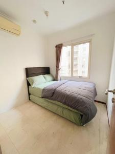 a bedroom with a bed and a window at Super Cozy 2BR Apt with direct access to Mall in Jakarta