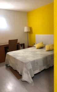 a bedroom with a large bed with yellow walls at Estudio privado in Los Gigantes in Acantilado de los Gigantes