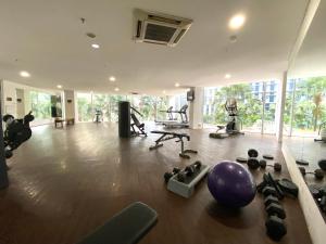a gym with exercise equipment in a large room at Super Cozy 2BR Apt with direct access to Mall in Jakarta