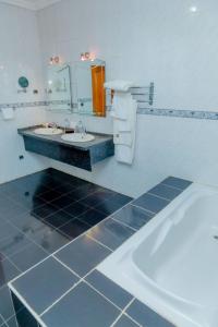 a bathroom with two sinks and a bath tub at Select Boutique Hotel Kigali in Kigali