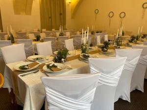 una mesa larga con mesas blancas y sillas blancas en Hotel Veveří, en Veverská Bítýška