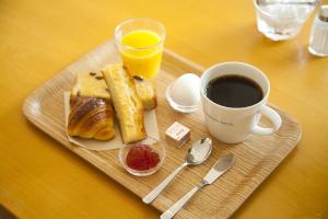 ein Tablett mit einem Teller Essen und einer Tasse Kaffee in der Unterkunft 7 Days Hotel in Kōchi