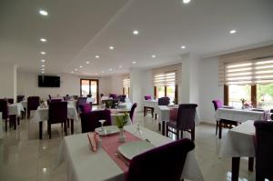 a dining room with white tables and purple chairs at DEFNE OTEL in Şile