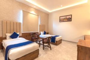 a hotel room with two beds and a table and chairs at THE TAJ PEARL HOTEL in Agra +189 photos