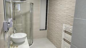 uma casa de banho com um lavatório e uma cabina de duche em vidro. em SQUARE HOTEL em Nîmes