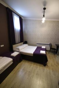 a hotel room with two beds and a table at Gyumri Guest House in Gyumri