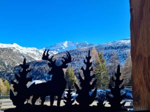 une statue de cerf devant une montagne dans l'établissement Chalet Selva, à Valdidentro