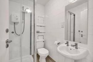 a white bathroom with a toilet and a sink at Bedford Place Hostels in London