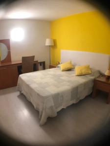 a bedroom with a large bed with two yellow pillows at Estudio privado in Los Gigantes in Acantilado de los Gigantes