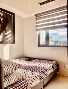 um pequeno quarto com uma cama e uma janela em Grass Fern Residences Tower 5 em Manila