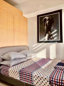 um quarto com uma cama com uma fotografia na parede em Grass Fern Residences Tower 5 em Manila