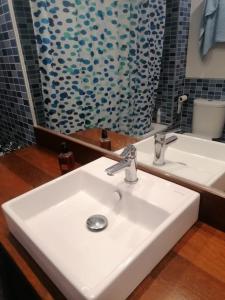 ein Badezimmer mit einem weißen Waschbecken und einem Spiegel in der Unterkunft Gimena playa in Vera