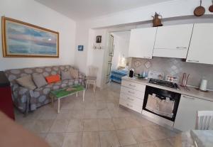a living room with a couch and a kitchen at La Petite Maison in Campolattaro