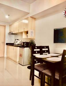 uma cozinha com uma mesa e cadeiras e um frigorífico em Grass Fern Residences Tower 5 em Manila