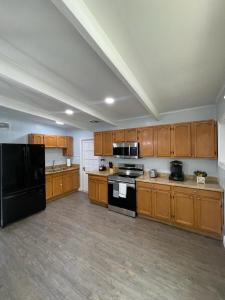 a large kitchen with wooden cabinets and black appliances at Cheerful Family Home Close To Everything! in Tampa