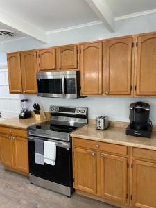a kitchen with a black stove and wooden cabinets at Cheerful Family Home Close To Everything! in Tampa