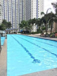 uma grande piscina em frente a edifícios altos em Grass Fern Residences Tower 5 em Manila