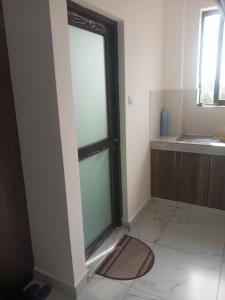 Puerta de cristal en una habitación con ventana en Amber Apartment, en Mombasa 7 fotos más