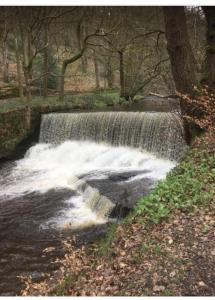 a small waterfall in the middle of a river at The Hideaway in Ripponden