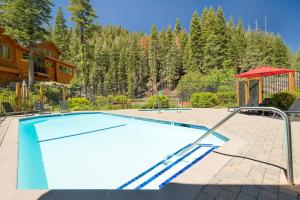 a swimming pool in a yard next to a house at Granite River Retreat at Alpine Meadows in Alpine Meadows