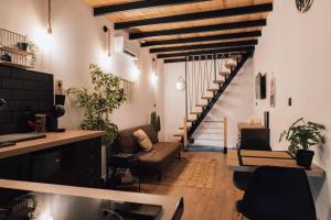 ein Wohnzimmer mit einem Sofa und einer Treppe in der Unterkunft Maison avec JACUZZI Privatif, L'Antre 2, WIFI,TV,CLIM in Bessan