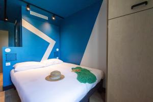 a bedroom with a bed with a hat on it at ibis Budget La Rochelle Centre in La Rochelle