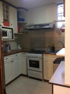a kitchen with a stove and a microwave at Samadri in Arequipa
