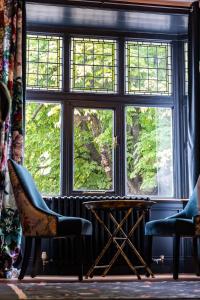 une chambre avec deux chaises et une table devant une fenêtre dans l'établissement Sleep at 55, à Tarporley