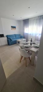 a living room with a table and a blue couch at Apartamentos Tarifa Sun in Tarifa