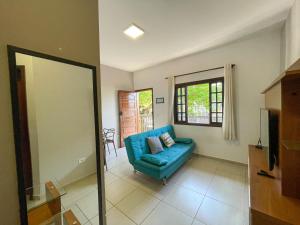 uma sala de estar com um sofá azul e uma janela em Apto Funcional próximo a Orla do Centro HS4 em Ubatuba