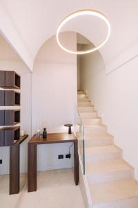 a stairway with a circular light fixture above a table and stairs at Suite1212 - Bandiera in Monopoli
