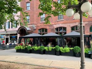 a restaurant with umbrellas and plants in front of a building at Hôtel des Coutellier in Quebec City