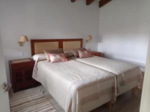a bedroom with a large bed with two pillows at El Nogal de Hualle in Treceño