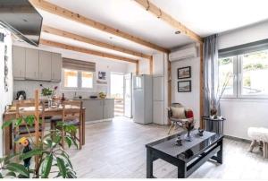 a kitchen and living room with wooden ceilings and a table at The Holiday House 3 in Heraklio