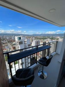 balcón con 2 sillas y vistas a la ciudad en Habitación Auxiliar en Apto Compartido piso 26, en Bucaramanga