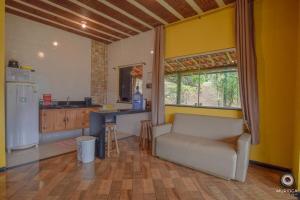 a living room with a couch and a kitchen at Casa do Vaz Lapinha da Serra in Santana do Riacho