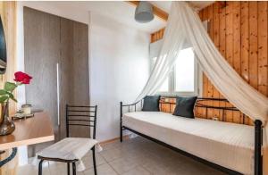 a bedroom with a bed and a desk and a window at The Holiday House 3 in Heraklio