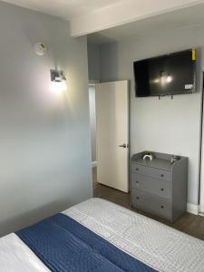 1 dormitorio con 1 cama y TV en la pared en Cheerful Family Home Close To Everything! en Tampa